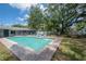 Backyard showcasing a pristine pool, poolside loungers, dining and mature trees at 14626 Wildwood Dr, Largo, FL 33774