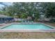 Sparkling in-ground pool surrounded by patio, lounge chairs and lush trees at 14626 Wildwood Dr, Largo, FL 33774