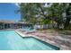 Sparkling pool with blue loungers, charming trees, and backyard patio at 14626 Wildwood Dr, Largo, FL 33774