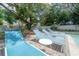 Backyard pool features blue loungers and a charming outdoor entertaining space at 14626 Wildwood Dr, Largo, FL 33774