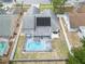 Aerial view of a home with a screened-in pool, solar panels, and a fenced backyard at 1472 Bay View St, Tarpon Springs, FL 34689