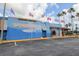 Commercial building with a blue facade adorned with murals and flags under a partly cloudy sky at 1472 Bay View St, Tarpon Springs, FL 34689