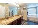 Bathroom featuring double sinks with granite countertops, a shower, and a soaking tub at 1521 Avondale Ridge Dr, Plant City, FL 33567