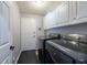 Laundry room featuring modern washer and dryer units with overhead cabinets at 1521 Avondale Ridge Dr, Plant City, FL 33567