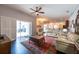 Open-concept living space with dark wood floors, sliding glass doors, and backyard views at 1521 Avondale Ridge Dr, Plant City, FL 33567