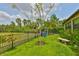 Manicured backyard with green grass, landscaping, and a stone bench near a fence at 15303 Valencia Del Sol St, Wimauma, FL 33598