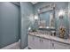 Elegant powder room featuring marble countertops, decorative sconces and mirror at 15303 Valencia Del Sol St, Wimauma, FL 33598