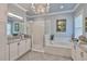 This stunning bathroom features a soaking tub, walk-in shower, and elegant granite countertops at 15303 Valencia Del Sol St, Wimauma, FL 33598