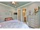 Serene bedroom with a large chest of drawers and doorway to the bathroom at 15303 Valencia Del Sol St, Wimauma, FL 33598
