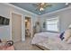 Light and airy bedroom with blue walls, herringbone floors, ceiling fan, and ensuite bathroom at 15303 Valencia Del Sol St, Wimauma, FL 33598