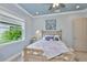Comfortable bedroom with a view of the lush backyard and light-colored walls at 15303 Valencia Del Sol St, Wimauma, FL 33598