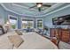 Primary bedroom with sitting area, tray ceiling, and large windows at 15303 Valencia Del Sol St, Wimauma, FL 33598
