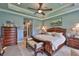 Spacious bedroom with tray ceiling, dark wood furniture, and neutral colors at 15303 Valencia Del Sol St, Wimauma, FL 33598