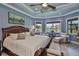 Comfortable primary bedroom with a cozy sitting area, large windows, and artwork at 15303 Valencia Del Sol St, Wimauma, FL 33598
