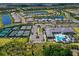 Expansive aerial view showcasing the community pool, tennis courts, and overall neighborhood layout at 15303 Valencia Del Sol St, Wimauma, FL 33598