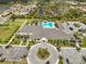Aerial view of the community clubhouse with swimming pool, parking, and meticulously landscaped grounds at 15303 Valencia Del Sol St, Wimauma, FL 33598