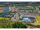 Aerial view of community center with a sparkling pool, tennis courts, and verdant landscaping at 15303 Valencia Del Sol St, Wimauma, FL 33598