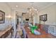 Dining room with tray ceilings, chandelier and open access to the living room at 15303 Valencia Del Sol St, Wimauma, FL 33598
