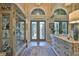 Spacious foyer featuring double doors, transom windows, tile flooring, and elegant furnishings at 15303 Valencia Del Sol St, Wimauma, FL 33598