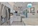 Modern kitchen features white cabinets, stainless appliances, and a view to the living room at 15303 Valencia Del Sol St, Wimauma, FL 33598