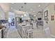 Bright, open kitchen with stainless steel appliances, marble island, and herringbone tile floors at 15303 Valencia Del Sol St, Wimauma, FL 33598