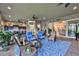 Spacious covered patio with blue furniture, outdoor kitchen, and view to the living room at 15303 Valencia Del Sol St, Wimauma, FL 33598