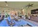 Covered patio with seating and view into living room through sliding glass doors at 15303 Valencia Del Sol St, Wimauma, FL 33598