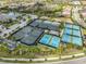 Aerial shot highlighting the community's well-maintained tennis and pickle ball courts and lush surroundings at 15303 Valencia Del Sol St, Wimauma, FL 33598