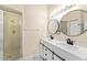 Well-lit bathroom with double vanity, modern fixtures, and a glass-enclosed shower at 1654 Portsmouth Lake Dr, Brandon, FL 33511