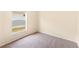 Cozy bedroom with neutral walls, carpeting, baseboard trim, and a bright window showcasing the outside at 1654 Portsmouth Lake Dr, Brandon, FL 33511