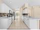 Bright kitchen with white cabinets, marble counters, stainless appliances, and open view to the breakfast nook at 1654 Portsmouth Lake Dr, Brandon, FL 33511