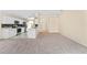 Open layout view of the kitchen area with appliances and a large carpeted living room at 1654 Portsmouth Lake Dr, Brandon, FL 33511