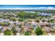 Aerial view of the home and its neighborhood with mature trees near the lake at 19910 Wyndmill Cir, Odessa, FL 33556