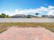 View of the backyard showing the brick patio, partial grass, and perimeter fence at 19910 Wyndmill Cir, Odessa, FL 33556