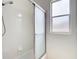 Bright bathroom displays shower with frosted sliding glass door and tiled walls at 19910 Wyndmill Cir, Odessa, FL 33556