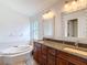 Bright bathroom with a double vanity, granite countertops, and large soaking tub at 19910 Wyndmill Cir, Odessa, FL 33556