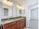 Bright bathroom featuring a double vanity with granite countertop and decorative framed mirrors at 19910 Wyndmill Cir, Odessa, FL 33556