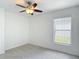 Bedroom features carpeted floors, a ceiling fan, and bright window at 19910 Wyndmill Cir, Odessa, FL 33556
