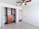 Bright bedroom features carpeted floors, a ceiling fan, and an open closet system at 19910 Wyndmill Cir, Odessa, FL 33556