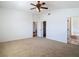 A spacious bedroom with carpet flooring, ceiling fan, and access to the ensuite bathroom at 19910 Wyndmill Cir, Odessa, FL 33556