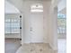 Bright foyer featuring tile flooring and an arched transom window above the white front door at 19910 Wyndmill Cir, Odessa, FL 33556