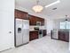 This kitchen features wood cabinets, stainless steel appliances, granite countertops, and white tile flooring at 19910 Wyndmill Cir, Odessa, FL 33556