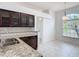 This kitchen features wood cabinets with glass doors, granite countertops, stainless steel appliances, and tile flooring at 19910 Wyndmill Cir, Odessa, FL 33556