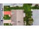 Aerial view of the house with manicured lawn, mature trees, landscaped garden beds, and an orange driveway at 2015 W Del Webb Blvd, Sun City Center, FL 33573