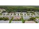 Aerial view of neighborhood homes with lush green lawns, mature trees, and a pond in the background at 2015 W Del Webb Blvd, Sun City Center, FL 33573