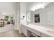 Spacious bathroom with dual sinks, a large mirror, a closet view, and a walk-through archway at 2015 W Del Webb Blvd, Sun City Center, FL 33573