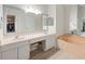 Bathroom featuring a large mirror, double sinks, wood floors, and an adjacent tub at 2015 W Del Webb Blvd, Sun City Center, FL 33573