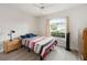 Cozy bedroom with a window, fan, and hardwood floors, offering a relaxing space at 2015 W Del Webb Blvd, Sun City Center, FL 33573