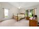 Bright bedroom with carpet flooring, vaulted ceilings, a bed, and multiple windows at 2015 W Del Webb Blvd, Sun City Center, FL 33573