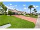 Beautiful single-story home with a well-manicured lawn, tidy landscaping, and a bright red driveway at 2015 W Del Webb Blvd, Sun City Center, FL 33573
